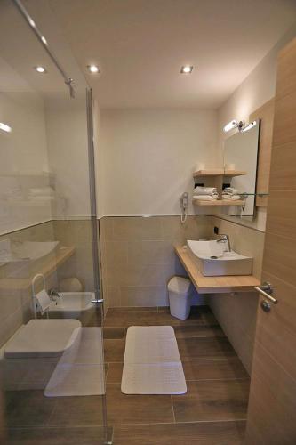 a bathroom with a sink and a shower at Garni Sayonara in Moena