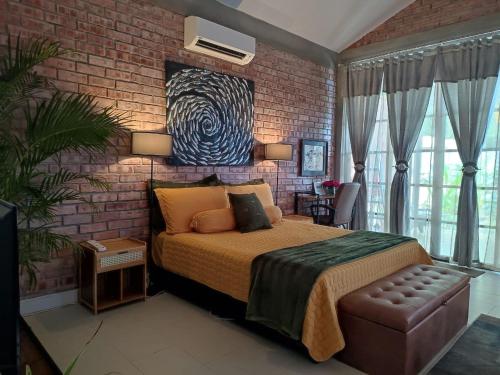 a bedroom with a bed and a brick wall at Forest Pool Villa in Ulu Melaka