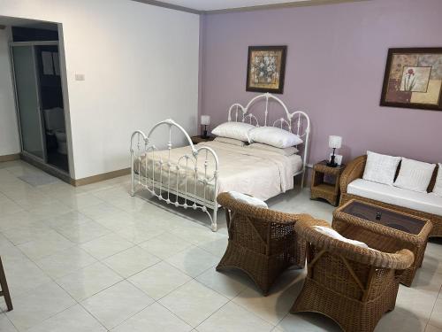 a bedroom with a bed and wicker chairs at Seaside Villa in Dauis