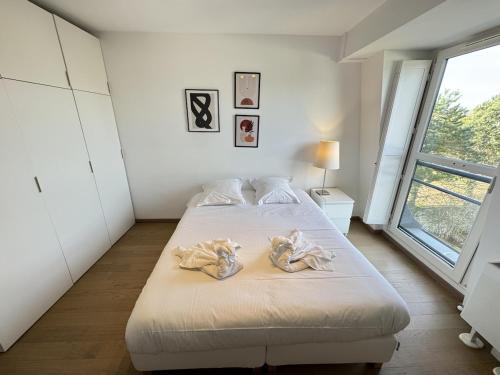 a bedroom with a bed with towels on it at Appartement moderne Senlis in Senlis