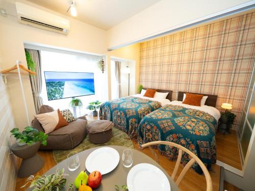 a hotel room with two beds and a couch at 旅鴉 inn 高松 in Takamatsu