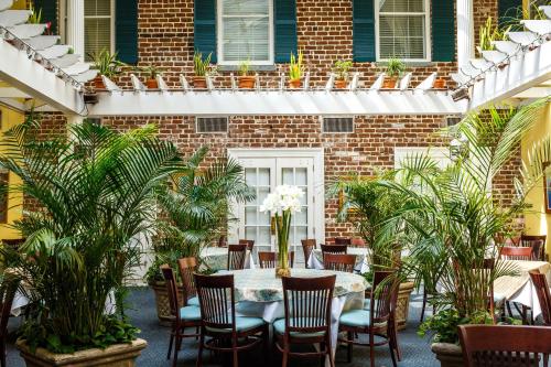 a patio with a table and chairs and a brick building at The Marshall House, Historic Inns of Savannah Collection in Savannah