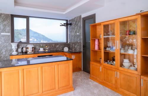 a kitchen with wooden cabinets and a window at The July - Coliving by Kegotel in Vung Tau