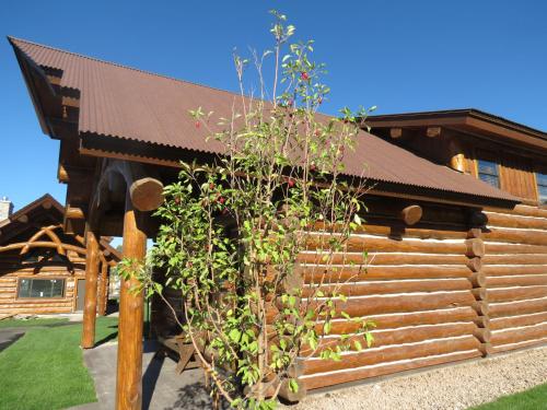 a log cabin with a wooden fence in front of it at Kodiak Mountain Resort in Afton