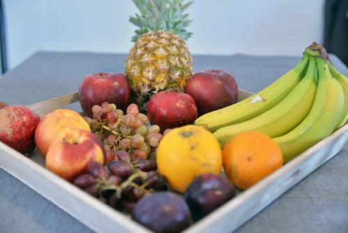 a tray of fruit with bananas apples and oranges at Hotel Anna Apartments in Kokkíni Khánion