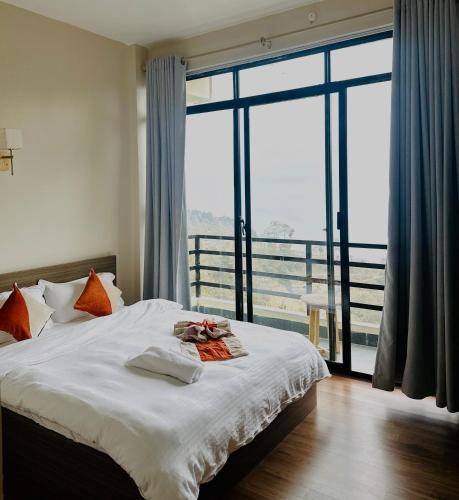 a bedroom with a bed and a large window at The Himalayan Ridge in Kathmandu