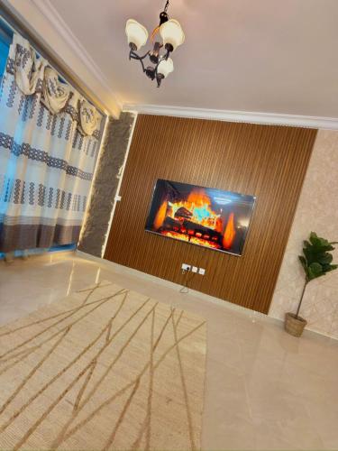 a living room with a flat screen tv on a wall at Beachfront Luxury Family Apartment with Pool, Gym, Jacuzzi - AJMAN Corniche UAE in Ajman
