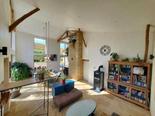 a living room with a table and a clock on the wall at Au Moulin du Miech in Salvagnac