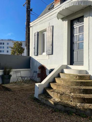a white house with stairs in front of it at Joli duplex rénové in Nevers