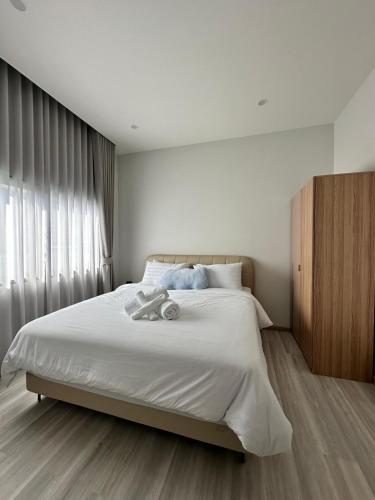 a bedroom with a large bed with white sheets at 2 Bedroom Modern House in Ban Nong Chaeng