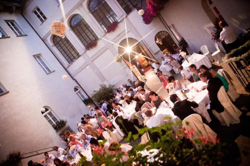 a group of people sitting at tables in a restaurant at Castello Di Compiano Hotel Relais Museum in Compiano