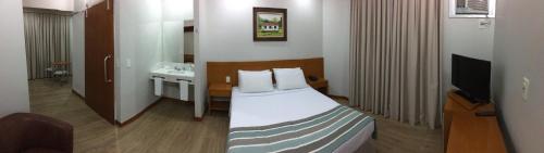 a hotel room with a bed and a television at Di Giulio Hotel in São José dos Campos