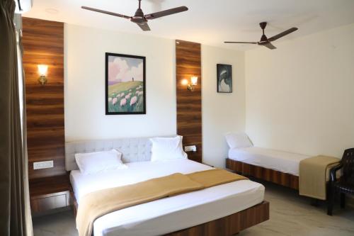 a bedroom with two beds and a ceiling fan at Hill Woods Yelagiri in Yelagiri