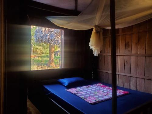 a room with a bed and a painting on the wall at Srey leaphome stay & trekking in Banlung