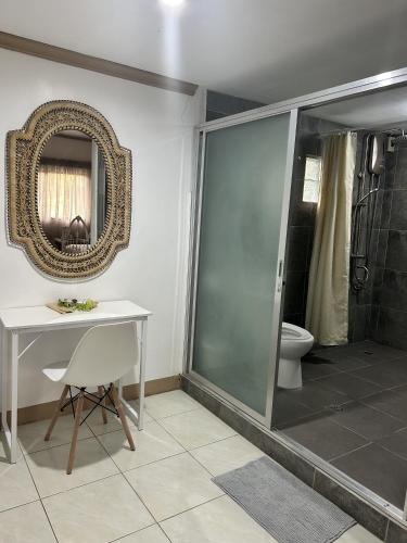 a bathroom with a toilet and a table and a mirror at Seaside Villa in Dauis