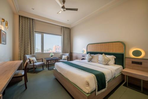 a hotel room with a large bed and a desk at Hotel Highway Prince Behror in Behror