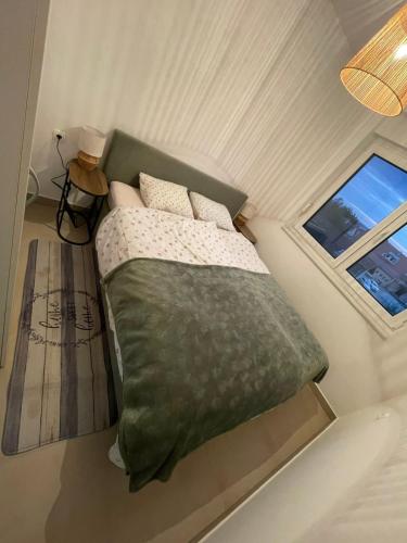 a bed in a small room with a window at BLANK apartman u centru in Bjelovar