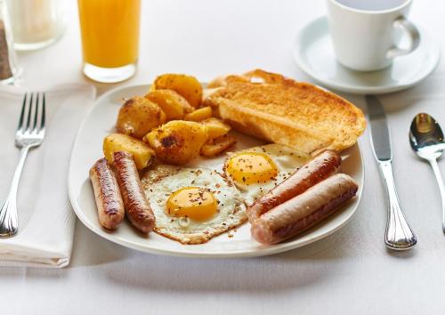 a plate of breakfast food with eggs potatoes and toast at Manchester Airport Stanley Hotel by Belvilla in Handforth