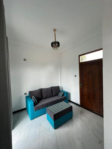 a living room with a blue couch and a door at Andrew Transit Villa - Near Airport in Katunayaka