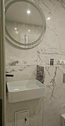 a bathroom with a white sink and a mirror at Trusted Home in Târgovişte