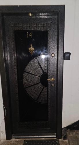a black door with a clock on it at Trusted Home in Târgovişte