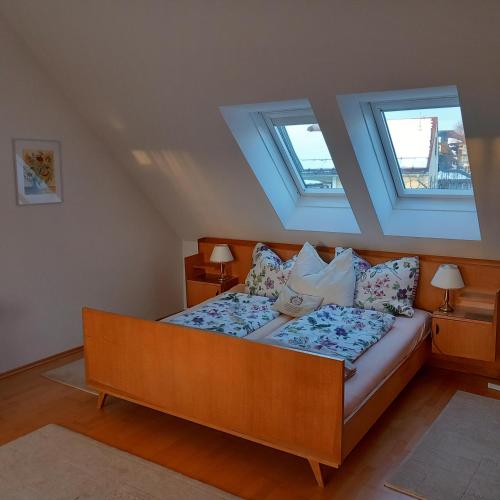 a bed in a room with two windows at Seekirchen Zentrum in Seekirchen am Wallersee