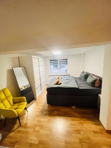 a bedroom with a bed and a yellow chair at Ferienhäuser Radebeul "Apartment Altkötzschenbroda" in Radebeul