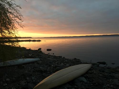 two surfboards on the shore of a lake at sunset at Las Juntas Ecolodge in Puyehue