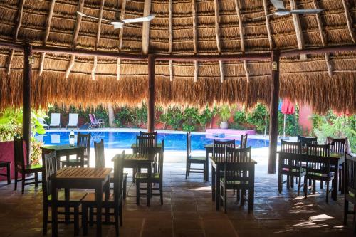 a restaurant with tables and chairs and a swimming pool at Casa Don Diego in Tulum