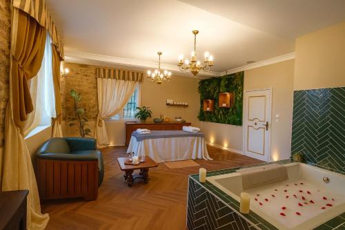 a bathroom with a tub and a bed in a room at Château de la Tourlandry in Chemillé