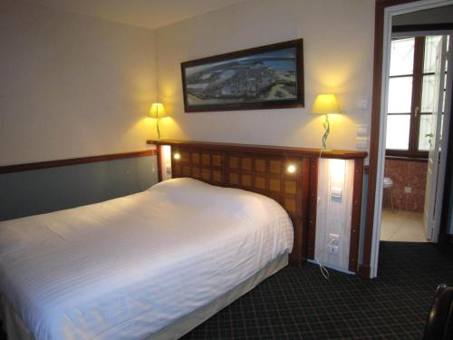 um quarto com uma cama e duas luzes na parede em Manoir Du Cunningham em Saint Malo