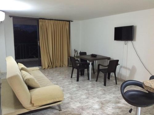 a living room with a couch and a table with chairs at Apartamento En San Andres in San Andrés