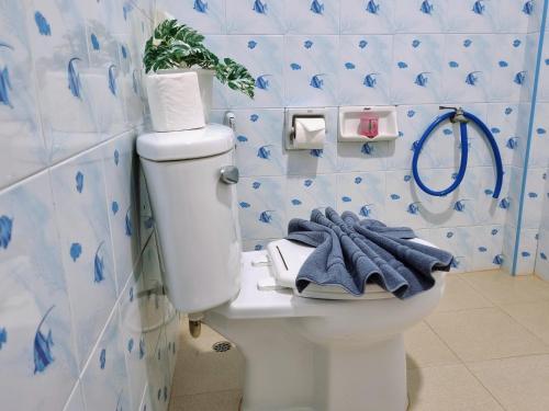 a bathroom with a toilet with blue and white tiles at Bang Yan Rimlay in Ko Yao Noi