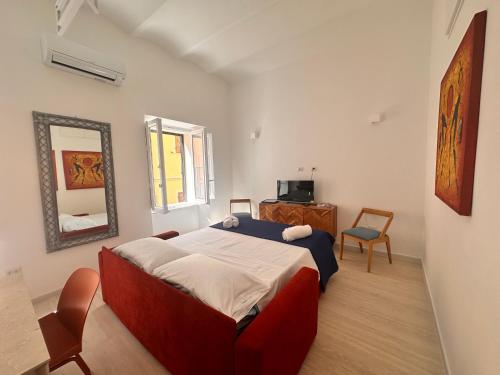 a bedroom with a large bed and a mirror at Vico Rosso - Milù Holidays La Maddalena in La Maddalena