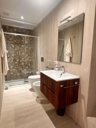 a bathroom with a sink and a toilet and a mirror at Vico Rosso - Milù Holidays La Maddalena in La Maddalena