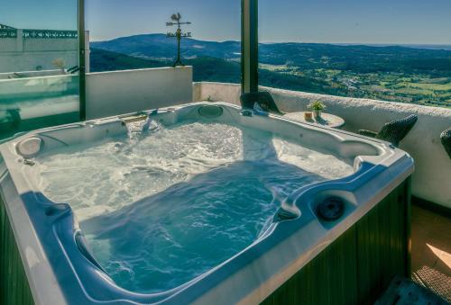 a jacuzzi tub with a view of the mountains at Dom Dinis Marvão in Marvão