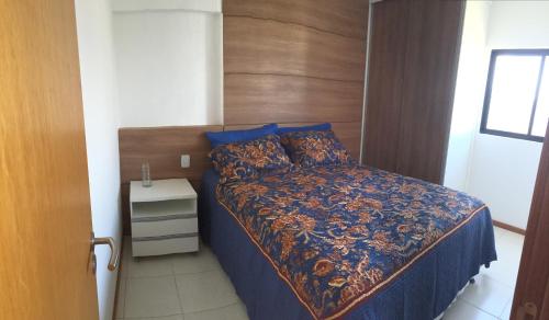 een slaapkamer met een bed met een houten hoofdeinde bij Apartamento Sol e Mar Maceió in Maceió