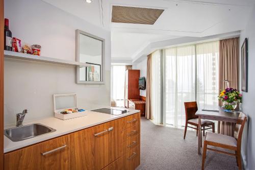 a kitchen with a sink and a table at Mantra Legends Hotel in Gold Coast