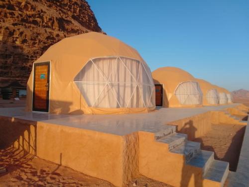 a group of domes in the desert with their shadows at DESERT HELO lUXURY CAMP & TOUR in Wadi Rum