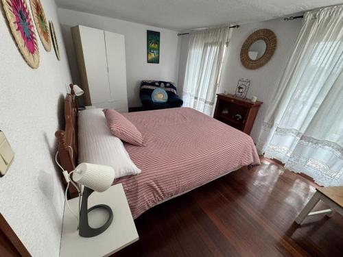 a bedroom with a large bed with a pink blanket at La casa del Rubio in Pedreña