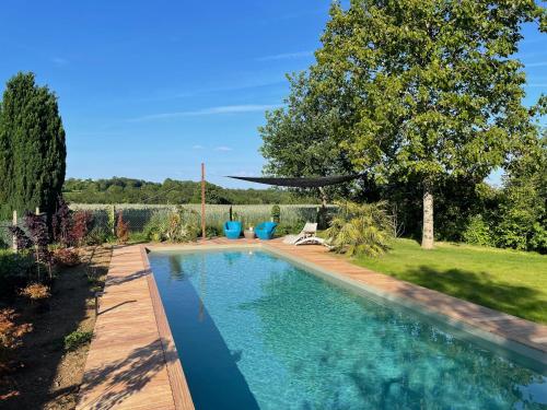 a swimming pool in a yard with a garden at Chez Mémé Delphine in Moutier-Malcard