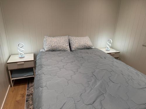a bedroom with a large bed with two night stands at Modern apartment in Drammen