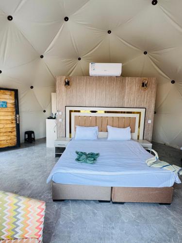 a bedroom with a large bed in a tent at DESERT HELO lUXURY CAMP & TOUR in Wadi Rum