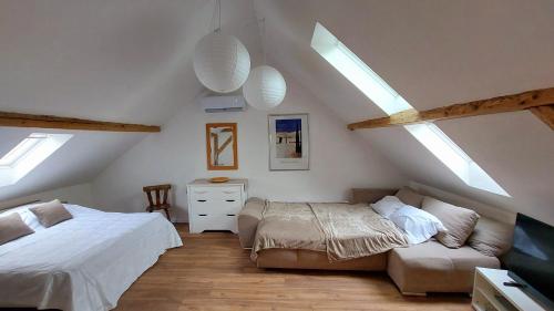 a attic bedroom with two beds and a couch at Large Private Room Near Colmar Center with Free Public Parking in Colmar