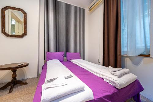 a bed in a room with purple and white sheets at Central House for up to 20 Guests Entire Place in Sofia