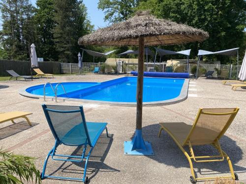 two chairs and an umbrella next to a swimming pool at Domaine du Château-Epinal in Épinal