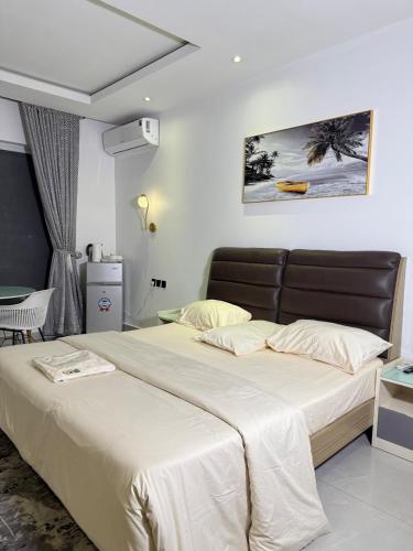 a bedroom with a large bed with white sheets at Precious Pavilion - Single Rooms in Abuja