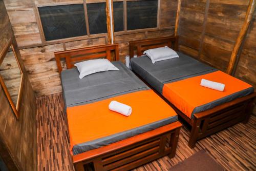 two beds in a room in a cabin at Nature Win Yala in Hambantota