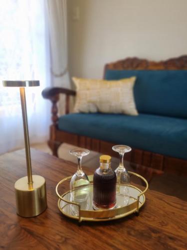 a table with a tray with two glasses and a lamp at Bultpark Apartment in Potchefstroom