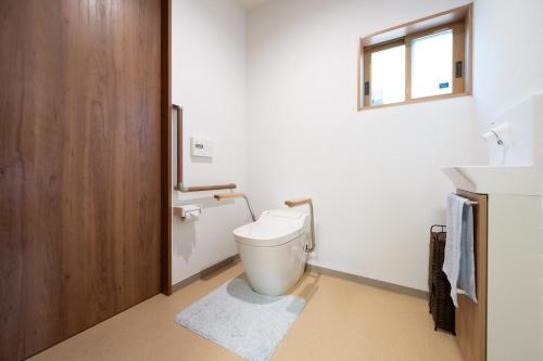 a bathroom with a toilet and a sink and a window at お宿 春Haru in Muromoto